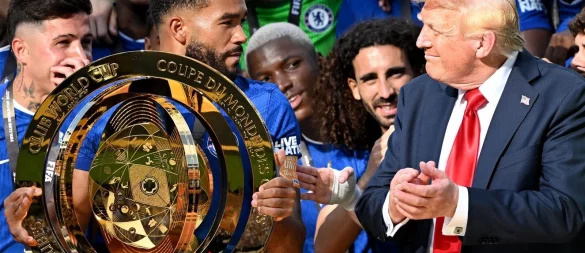 Chelseas Kapitän Reece James (l/vorn) hält auf dem Siegerpodest die Trophäe in den Händen und schaut irritiert zu US-Präsident Donald Trump. - © Sven Hoppe/dpa