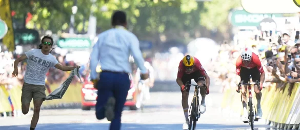 Während Jonas Abrahamsen und Mauro Schmid (r) in Toulouse um den Sieg sprinten, läuft ein Flitzer (l) auf die Zielgerade. - © Thibault Camus/AP/dpa