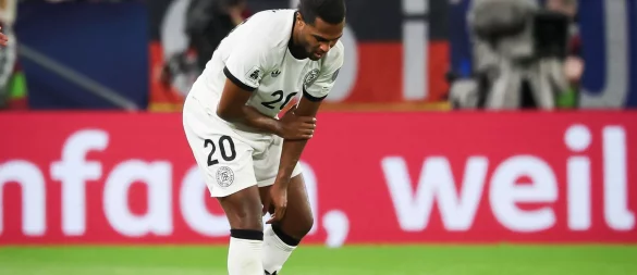 Serge Gnabry fasst sich in Bratislava an den verletzten linken Arm. - © Christian Charisius/dpa