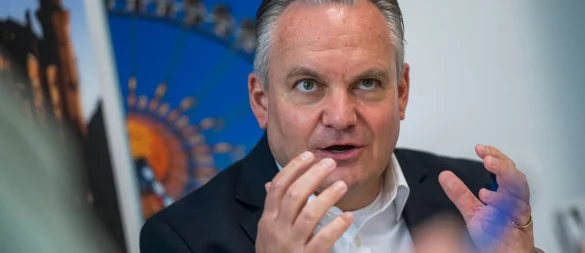 Münches neuer Wiesnchef Scharpf vor einem Foto des Riesenrades. - © Peter Kneffel/dpa