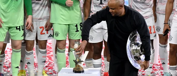 Bayern-Trainer Vincent Kompany stellt bei der Meisterparty eine Kakadu-Figur auf den Sockel. - © Sven Hoppe/dpa