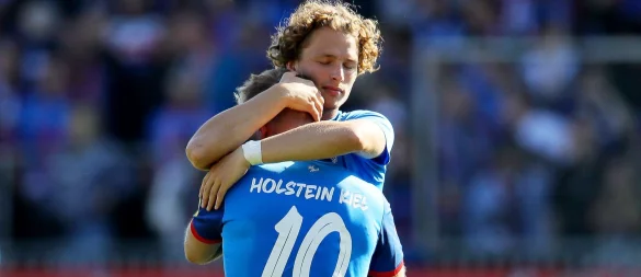 Kiels Lewis Holtby (vorne) wird nach dem Abstieg von Teamkollege Fiete Arp getröstet. - © Claus Bergmann/dpa