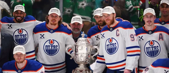 Leon Draisaitl posiert hinter Kapitän Connor McDavid mit dem Pokal für den Sieger der Western Conference. - © Julio Cortez/AP/dpa