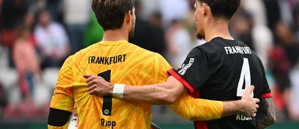 Kevin Trapp (l) fehlt im Pokal-Kader von Eintracht Frankfurt und hat die Kapitänsbinde an Robin Koch abgegeben. - © Jan-Philipp Strobel/dpa