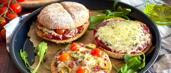 Ein rustikales Hamburgerbrötchen wird zur Pizzabasis, belegt mit Tomatenketchup, geschmolzenem Mozzarella und mediterranen Zutaten. - © Anja Würfl/die-frau-am-grill.de/dpa-tmn