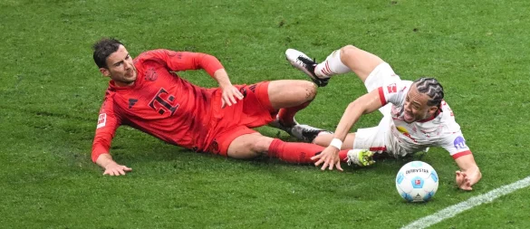 Leon Goretzka (l) und Leipzigs Xavi Simons kämpfen um den Ball. - © Hendrik Schmidt/dpa