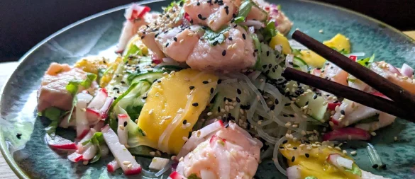 Der Glasnudelsalat mit Lachs-Ceviche wird mit gerösteten weißen und schwarzen Sesamkörnchen getoppt. - © Doreen hassek/hauptstadtkueche.blogspot.com/dpa-tmn