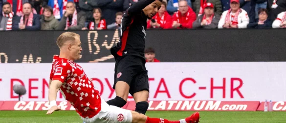 Der FSV Mainz 05 um Andreas Hanche-Olsen (l) und Eintracht Frankfurt um Hugo Ekitiké (r) lieferten sich ein hitziges Derby - © Torsten Silz/dpa