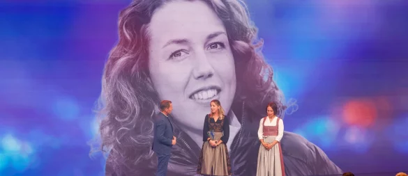 Die Biathletinnen Franziska Preuß und Magdalena Neuner (hier mir Moderator Markus Othmer vor einem Bild von Laura Dahlmeier) haben bei der Verleihung des Bayerischen Sportpreises ihrer gestorbenen Kollegin Dahlmeier gedacht. - © Alexandra BEIER/BayStMI/dpa