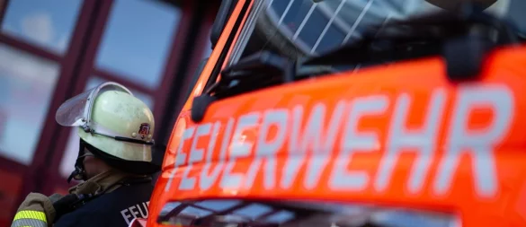 Eine Einsatzkraft der Feuerwehr steht neben einem Einsatzfahrzeug der Feuerwehr. - © Marijan Murat/dpa