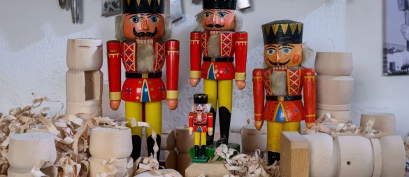 Historische Nussknacker und der Mini-Nussknacker «Willhelm», der 2021 auf der Internationalen Raumstation ISS zu Gast war, stehen in der Werkstatt von Holzspielzeugmacher Markus Füchtner in Seiffen. - © Hendrik Schmidt/dpa