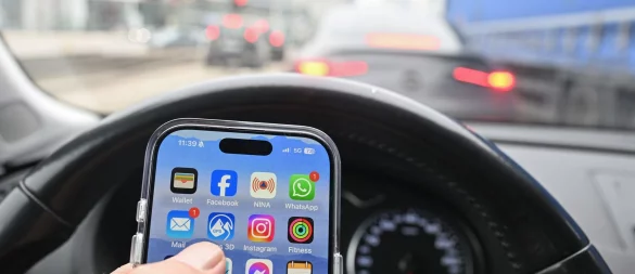 Nein, schlechte Idee: Wer im Auto ein Smartphone nutzen will, fährt besser rechts ran - und schaltet den Motor ab. Sonst könnte es teuer werden - gefährlich allemal. - © Bernd Weißbrod/dpa