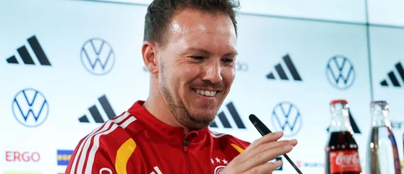 Julian Nagelsmann richtet das Mikrofon bei der Pressekonferenz. - © Christian Charisius/dpa