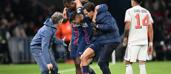 Auf Betreuer gestützt wird der am Fuß verletzte PSG-Spieler Achraf Hakimi (M) vom Platz geführt. - © Federico Gambarini/dpa