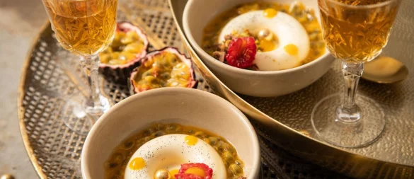 Panna Cotta mit Passionsfrucht, Himbeere, Mangotupfer, Minze, Pistazie, Schokolade und goldenen Schokokugeln in Savarin-Form zubereitet. Das ist eine Backform in flacher, ringförmiger Gestalt. - © Christin Klose/dpa-tmn