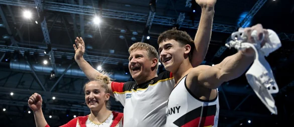Karina Schönmaier und Trainer Anatol Ashurkov (M) jubeln mit Timo Eder über EM-Gold. - © Marijan Murat/dpa