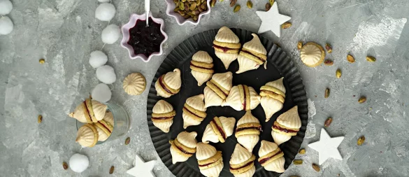 Durch die Geleefüllung werden zwei Vanillekipferl miteinander verbunden. Dann bekommt der Doppel-Keks auch noch zwei Zipfelmützchen in Form von Baiserhauben. - © Mareike Pucka/biskuitwerkstatt.de/dpa-tmn