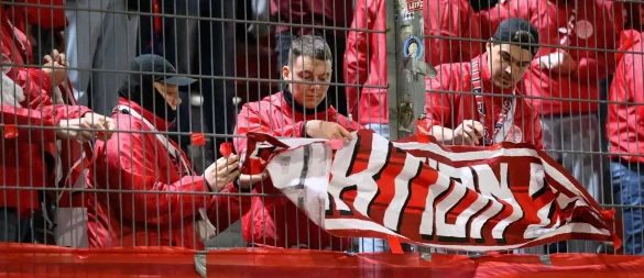 Leipzigs Fans nehmen zu Beginn der zweiten Halbzeit die Fahnen ab. Vor Beginn des Spiels war ein Fan vor dem Stadion verstorben. - © Robert Michael/dpa
