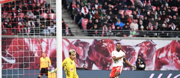 Bremens Torwart Mio Backhaus (l, Werder Bremen) und Ridle Baku (RB Leipzig) schauen dem Ball hinterher. Backhaus verhinderte mit seinen Paraden einen frühen Rückstand der Gäste in Leipzig. - © Jennifer Brückner/dpa