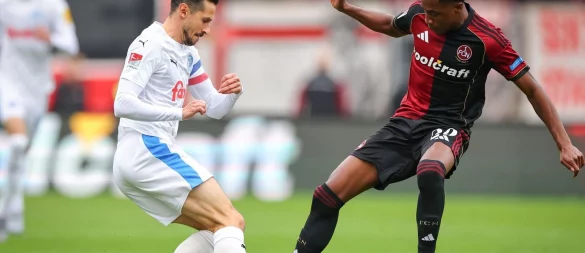 Kiel-Kapitän Steven Skrzybski (links) und Pape Demba Diop von Nürnberg kämpfen um den Ball. - © Daniel Karmann/dpa