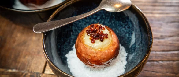 Diese Vorspeise schindet Eindruck: Die Zwiebel wird langsam bei niedriger Temperatur eingekocht und dann gefüllt. Getoppt wird sie mit Linsen und auf einem Bett aus Meersalz serviert. - © Christin Klose/dpa-tmn