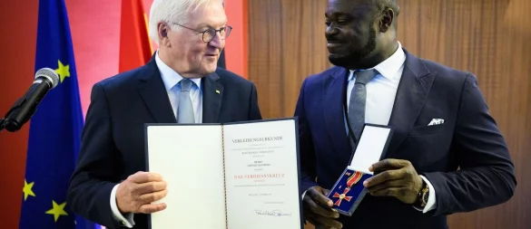 Der frühere Fußball-Nationalspieler Gerald Asamoah (r) erhält von Bundespräsident Frank-Walter Steinmeier das Bundesverdienstkreuz. - © Bernd von Jutrczenka/dpa