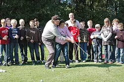 Auf dem Gr&uuml;n: W&auml;hrend die Sch&uuml;ler-Gruppe zusieht, f&uuml;hrt Profi-Golfer Andrew Parker die Arme von Lisa Marie Cilbiyikoglu beim Schlag. - &copy; Foto: Gallisch