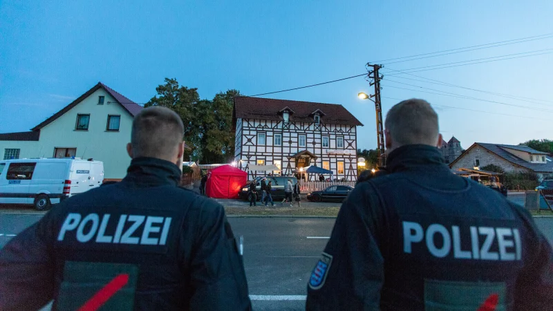 Anhänger der rechten Szene treffen sich zu einem Neonazi-Konzert während die Polizei das Geschehen überwacht. - © Symbolbild: Steffen Ittig/picture alliance/dpa