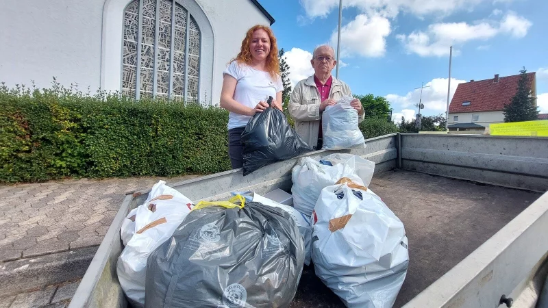 Maja Settertobulte bringt eine T&uuml;te mit aussortierter Kleidung zum Abholort vor der katholischen Kirche St. Michael an der Marktstra&szlig;e. Arnold Wanke nimmt sie entgegen. Fotos: Karin Prignitz - &copy; Karin Prignitz