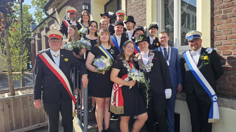 Oberst Michael Kr&uuml;germeyer-Kalthoff (links), B&uuml;rgermeister Matthias Kalkreuter (Zweiter von rechts) und Pressesprecher Bj&ouml;rn Cruel (rechts) bilden den Rahmen f&uuml;r den Thron der Sch&uuml;tzengilde der Stadt Lage von 1509. Das K&ouml;nigspaar sind Denise Freudenberg und Ren&eacute; Altekr&uuml;ger (vorne). Dahinter stehen Florian Freudenberg, Ellen Drexhage, Moritz Dierks, Sonja Altekr&uuml;ger, Christoph Schmidt, Sabrina Wall, Erik Freitag, Alexandra Werner, Max Billerbeck und Marisa Freitag. Hinten stehen die Thron-Offiziere Viktor D&uuml;ck und Dirk Wrede. - &copy; Astrid Sewing