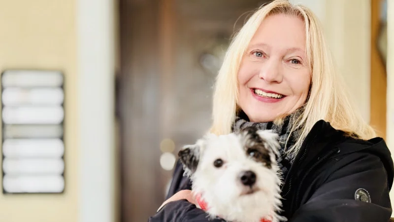Soziotherapeutin Anja Sch&ouml;ndienst aus Bielefeld sitzt mit Begleith&uuml;ndin Hedi auf einer Bank vor ihrer alten Praxis. - &copy; Stefan Becker