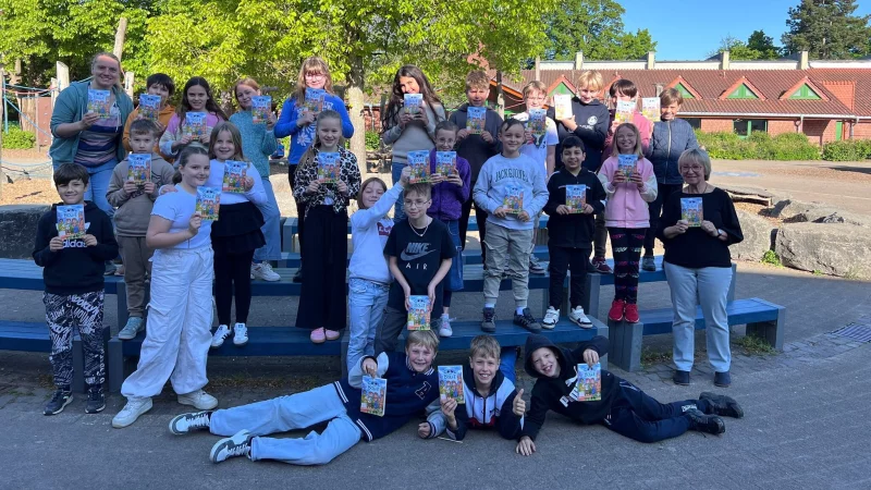 Die Schülerinnen und Schüler der Grundschule Nord haben von Buchhändlerin Martina Lange (rechts) das Buch bekommen. - © Grundschule Nord