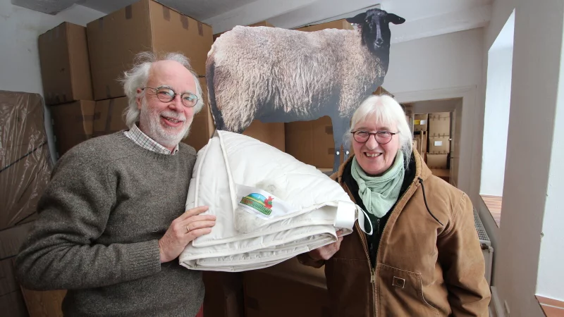 &Ouml;ko-Unternehmer Dr. Bernd Nagel-Held und Sch&auml;ferin Karla Ebert im Wolldecken-Lager. Schaf "Claudia" im Hintergrund ist nicht echt. - &copy; Jens Rademacher