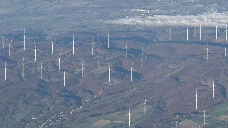 Das Bild zeigt eine Luftaufnahme, in der zu den bestehenden Anlagen auf dem Bauerkamp die geplanten Windkraftanlagen von Stephan zur Lippe und Landesverband Lippe maßstabsgerecht eingezeichnet sind. Umgeben von Windkraftanlagen das Dorf Kohlstädt, unten rechts die Anlagen, die sich von Schlangen zum Bauerkamp hochziehen. - © Montage: Nationalparkfreunde/Peter Allroggen