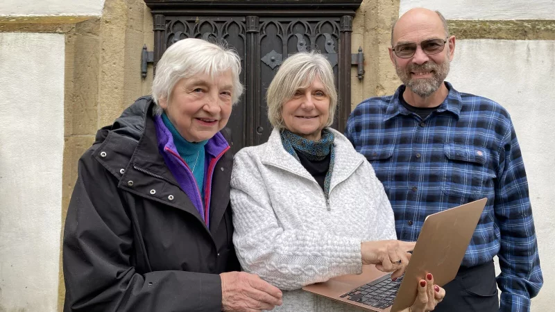 Ahnenforschung mit Laptop und Internet. Sonja Ruthe (Mitte) aus Victoria in Kanada fand ihre Vorfahren in unserer Region. Mit ihrem Mann Johann Cunningham und Inge Berghoff vom Heimatverein Oerlinghausen, die sie bei ihren Recherchen unterstützte, steht sie vor der sogenannten Hochzeitstür der Alexanderkirche. - © Foto: Horst Biere