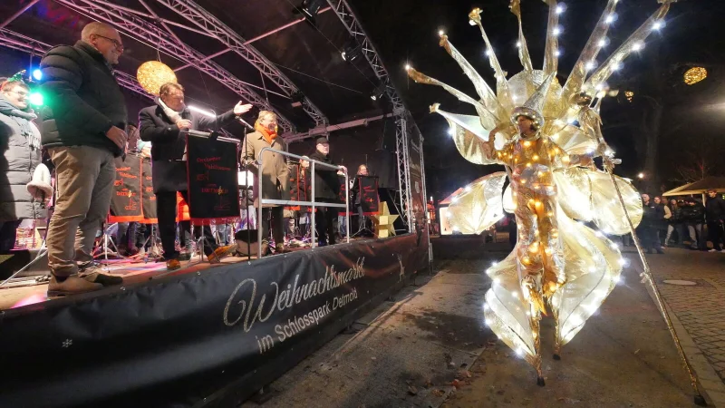 Eine goldene Lichtgestalt auf Stelzen markierte nach den Reden von Bürgermeister Frank Hilker (links Mitte), Stephan Prinz zur Lippe (links, rechte Seite) und Werbegemeinschaftsvorsitzendem Christian Schmidt (links, linke Seite) die Eröffnung des Detmolder Weihnachtsmarkts. - © Jost Wolf