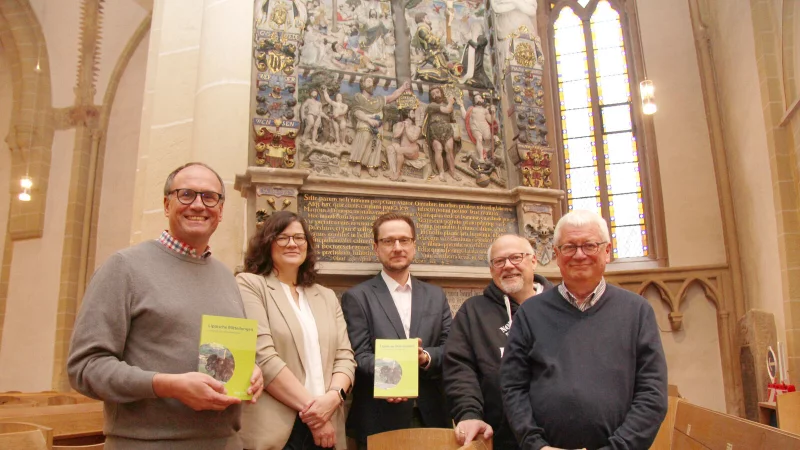 Superintendent Dr. Andreas Lange (von links), Julia Kathke, Henning Bovenkerk, Tom Steinlein und Jürgen Scheffler stehen vor dem Donop-Epitaph in der Kirche St. Nicolai. Auf dem ist oben rechts Christina von Kerssenbrock zusammen mit Moritz von Donop kniend unter dem Kreuz zu sehen. Ein Beitrag aus den "Lippischen Mitteilungen" befasst sich mit den Spuren frühneuzeitlichen Frauenlebens. - © Nadine Uphoff