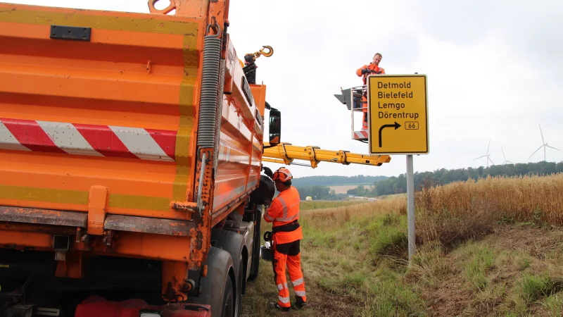 Die Arbeiter wechseln die Wegweiser für die Barntruper Umgehung aus. - © Nadine Uphoff