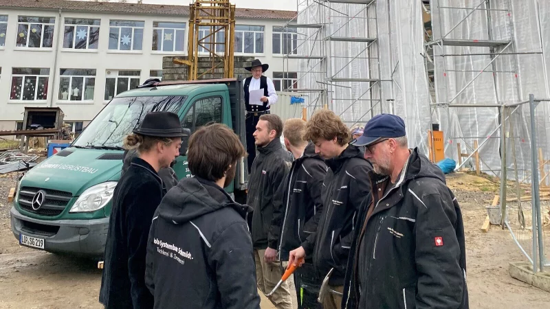 Richtfest an der Realschule I: Die Zimmerleute klopfen Hillebille, während Meister Christian Schmidt den Richtspruch hält. - © Stadt Detmold