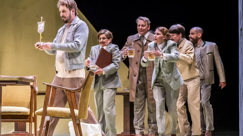 Herr Adam (Hartmut Jonas) trägt den Vereinswimpel der DAFV, dahinter Manuela Stüßer, Patrick Hellenbrand, Magdalena Weiß, Rebecca Stute und Jan-Niklas Shadan Mavigök. - © Landestheater Detmold/Jochen Quast