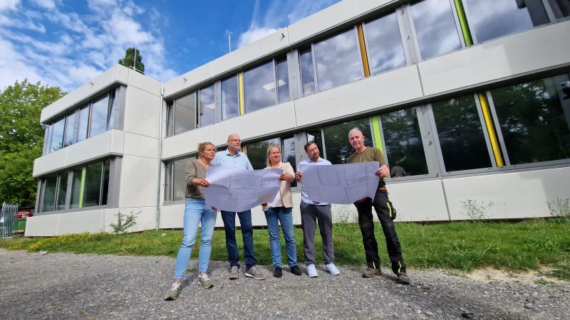 Stehen vor der frisch gestrichenen Fassade der Grundschule Langenholzhausen mit den Plänen in der Hand: Schulleiterin Irina Müller (von links), Fachbereichsleiter Olaf Kapelle, Bauamtsleiterin Ewa Hermann, Bauleiter Nikolai Stoll und Hausmeister Dirk Frevert. - © Nadine Uphoff