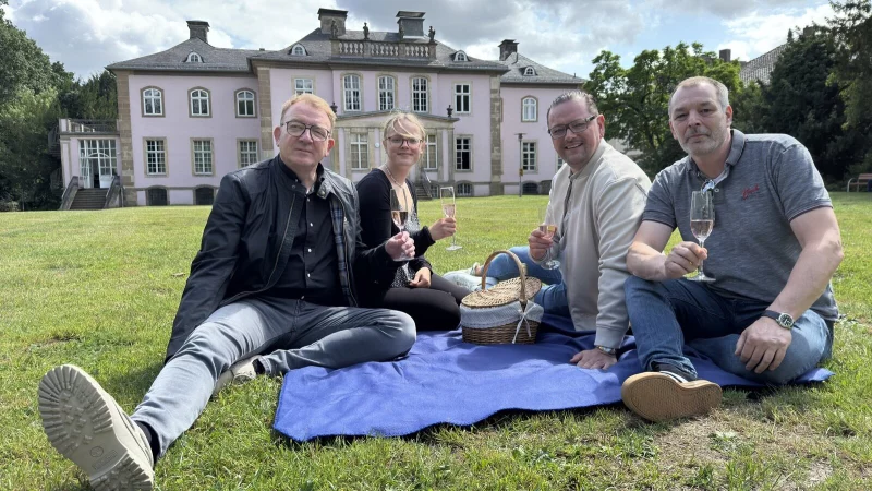 André Schröder (Bürgerverein, von links), Francesca Rackow (Stadtmarketing), Maximilian Janski (Bürgerverein) und Oliver Siekmann (Stadtmarketing) laden zum "Jazz im Park" samt Picknick vor dem Schloss Stietencron ein. - © Sven Kienscherf