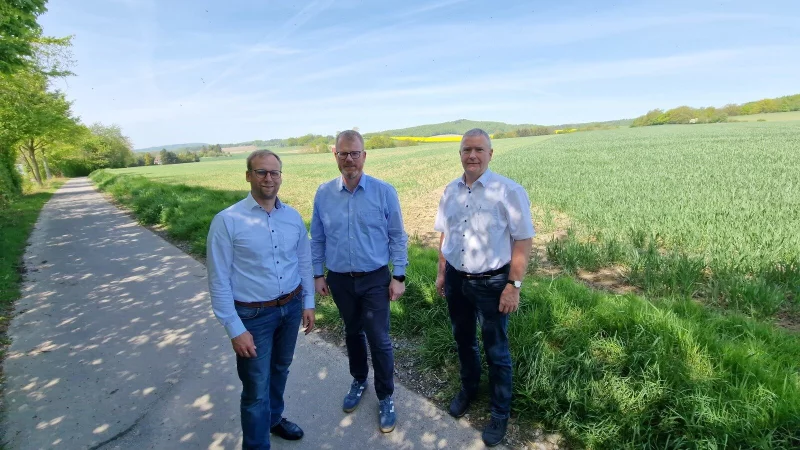Barntrups Bürgermeister Borris Ortmeier (von links), Dörentrups Bürgermeister Friso Veldink und Extertals Kämmerer Hubertus Fricke stehen in Humfeld. Im Hintergrund ist das Gelände zu sehen, das zum interkommunalen Gewerbegebiet werden soll. - © Nadine Uphoff