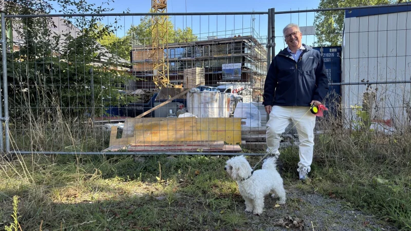 Dr. Johann Malcher steht mit Hund vor der Festhalle, die derzeit saniert wird. - &copy; Sven Kienscherf