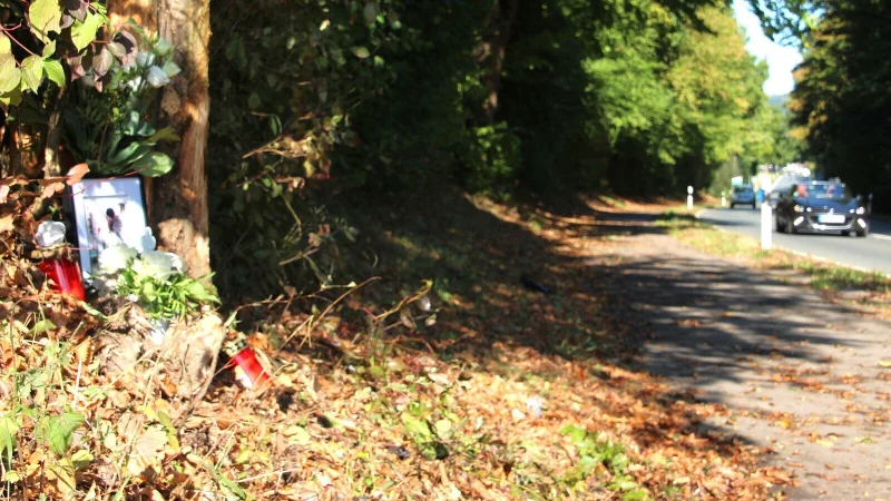 An der Unfallstelle erinnern am Dienstag ein gerahmtes Foto- wei&szlig;e Blumen und Grablichter an den 20 Jahre alte Pyrmonter, der am Montagabend infolge eines Verkehrsunfalls ums Leben kam. - &copy; Juliane Lehmann