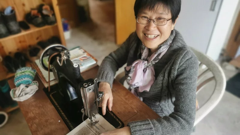 Jing Lin hat die N&auml;hmaschine, an der sie arbeitet selbst repariert. - &copy; Sylvia Frevert