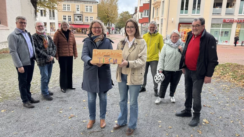 Michael Biermann, Helmut Behnisch, Pfarrerin Birgit Schneider, Ulrike Upmeyer, Benita Henning, Gerd Bicker, Christiane Dorß-Dierker sowie Manfred Hilbrink-Späth (von links) halten nicht nur symbolisch den "DemokraTisch", sondern grundsätzlich demokratische Werte hoch. - © Sandra Castrup