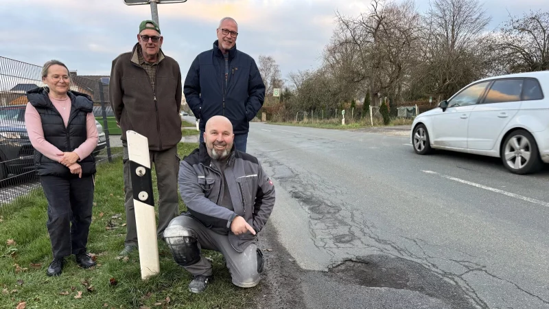 Susanna Radic, Dirk Brinkmann, Detlef Wunderlich (von links) sowie Niko Radic (knieend) an der viel befahrenen Sorrenheider Stra&szlig;e, an der sich zahlreiche Schlagl&ouml;cher und Unebenheiten befinden. - &copy; Sandra Castrup