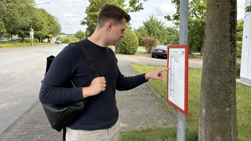 LZ-Mitarbeiter Jan Schillmann studiert an der Haltestelle "Westerfeldstraße" den Fahrplan. Er wartet auf die Buslinie 750. - © Raphael Bartling