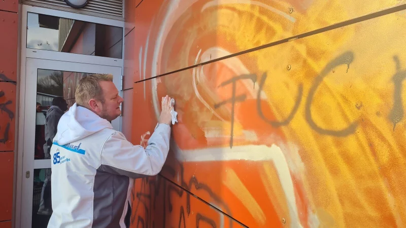 M&uuml;hevolle Kleinarbeit: Malermeister Falk H&ouml;tger probiert es erst mal mit L&ouml;sungsmittel, um die Schmiererei an der Wand &uuml;ber dem Flachdach zu entfernen. Bei Gold und Schwarz klappt das zun&auml;chst ganz gut, das Silber ist hartn&auml;ckig. - &copy; Marianne Schwarzer